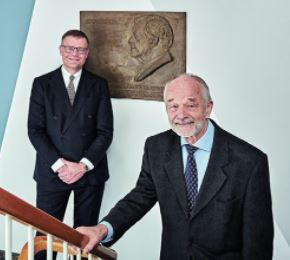 Jens Kann-Rasmussen (left) and Hans Kann Rasmussen in front of a relief of the founders of the foundations, Villum Kann Rasmussen.